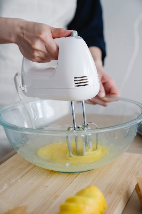 Person using hand mixer to beat eggs