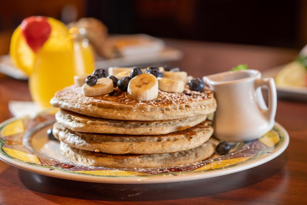 Tall stack pancakes with bananas and blueberries