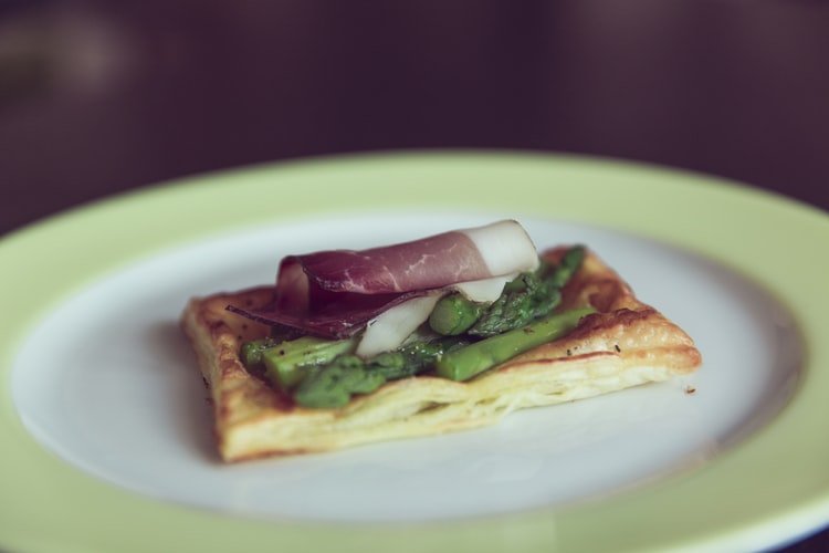 pancetta on a thin slice of bread with asparagus