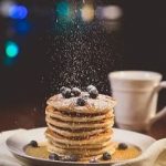 Powdered sugar is sprinkled on pancakes