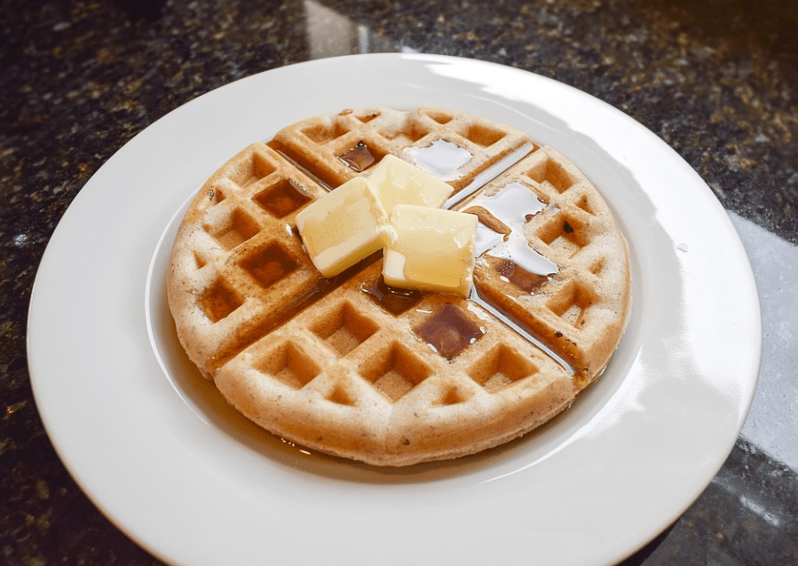 waffle topped with butter and syrup on a plate