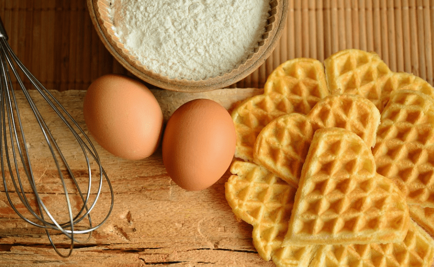 heart-shaped waffles, eggs, whisk, a bowl of flour