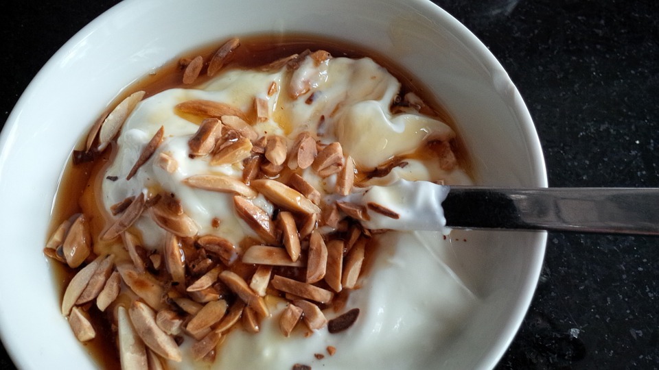 a bowl of yogurt with almonds and maple syrup