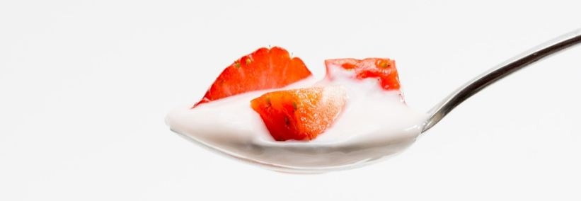 a spoonful of yogurt with strawberry bits