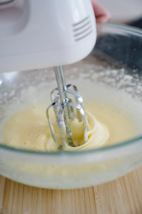 Person using a hand mixer to mix the batter