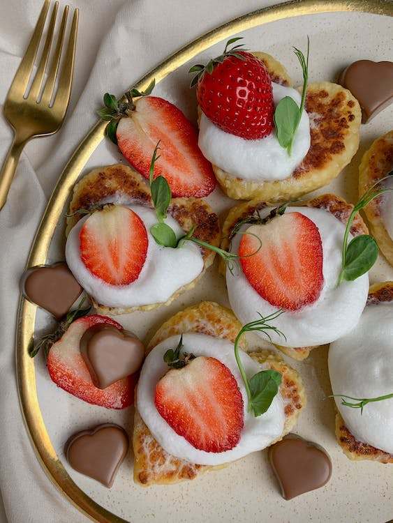Heart pancakes with cream and strawberries