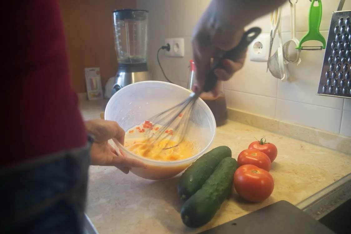 Photo a person beating eggs using a wire whisk