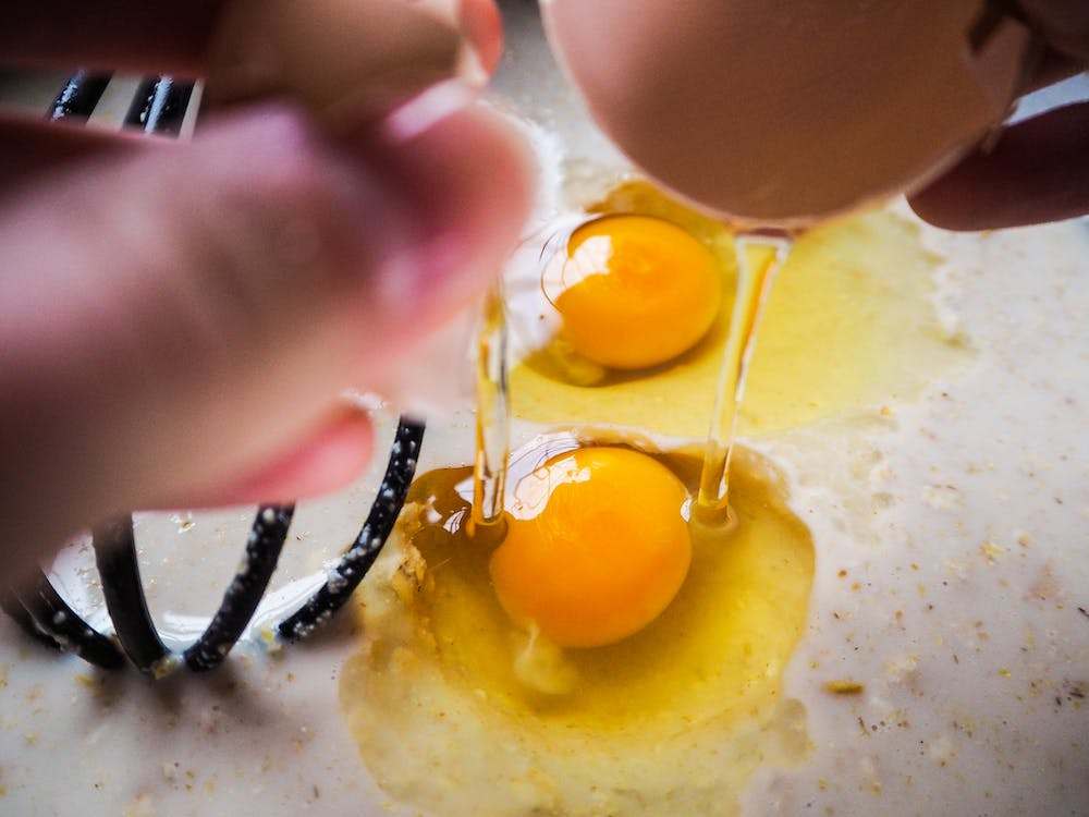 Photo close up shot of a person cracking an egg
