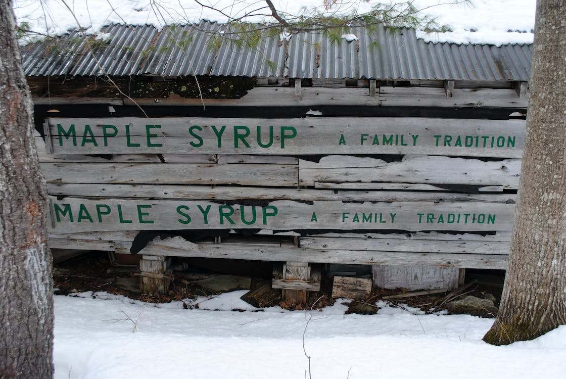 Rural wooden construction with inscription maple syrup in winter countryside